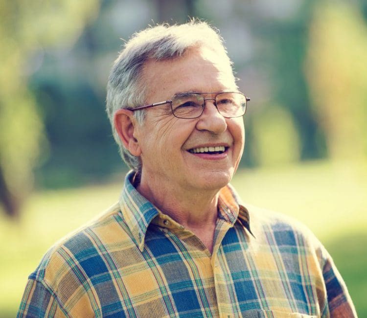older man with glasses smiling at camera