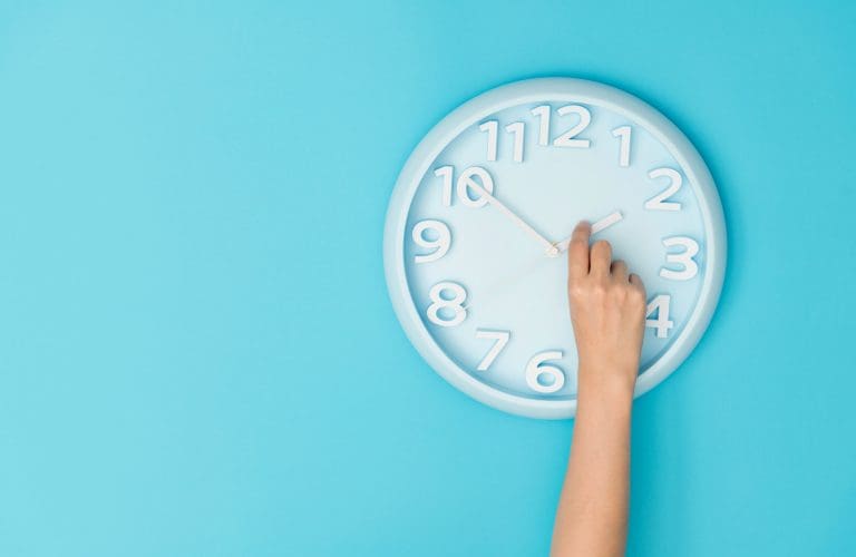 Human hand adjusting the hour clock for daylight savings time