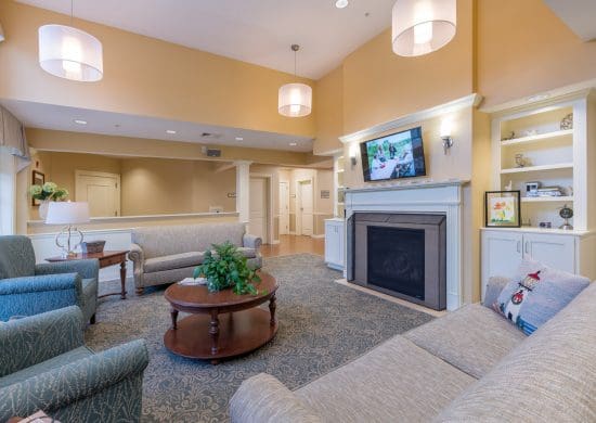 sitting area with couches, chairs, and tv above fireplace