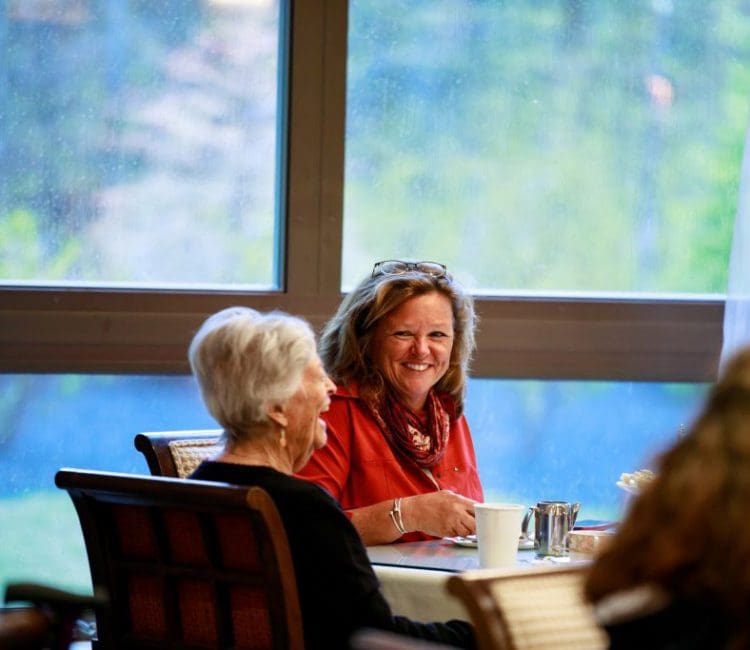 daughter and mother sitting together at a table smiling