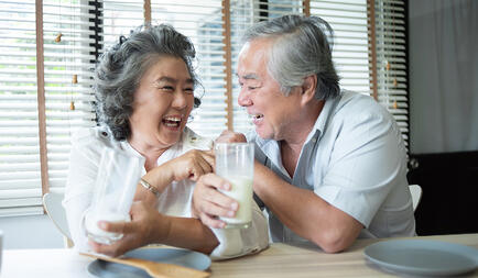 Healthy eating is so important, this older couple is laughing enjoying a glass of milk
