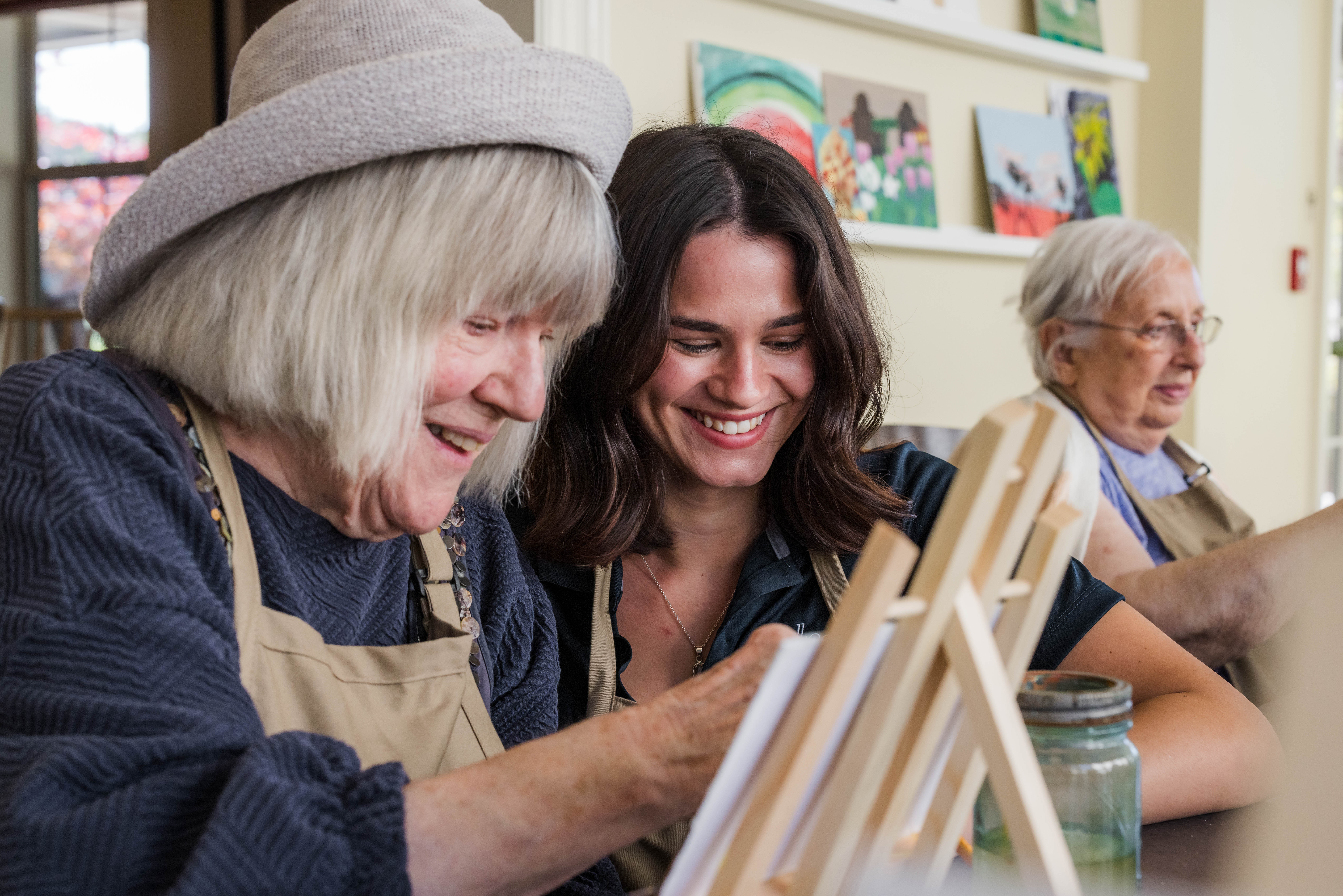 2 women (one younger and one older) painting on canvas