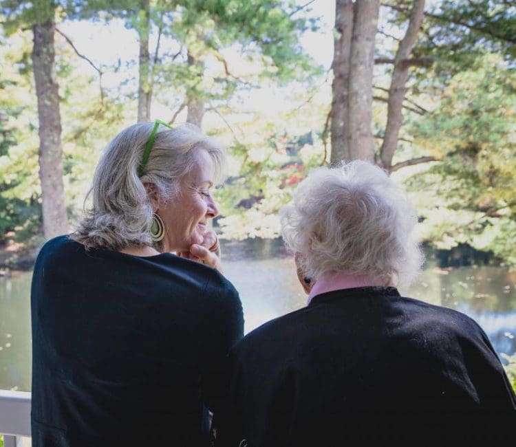two residents with their backs facing the camera, looking at the water