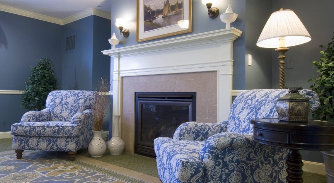 fireplace in sitting area with chairs beside