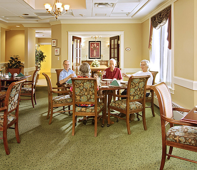 granite hill estates dining room with a table of residents sitting and eating together