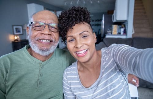 Senior father takes photo with adult daughter