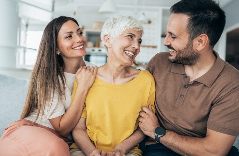 Portrait of happy senior woman with her adult offspring talking about assisted living