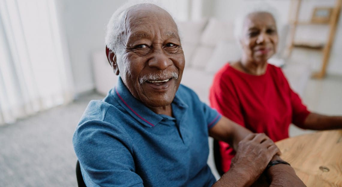 man smiling in blue shirt at senior living community