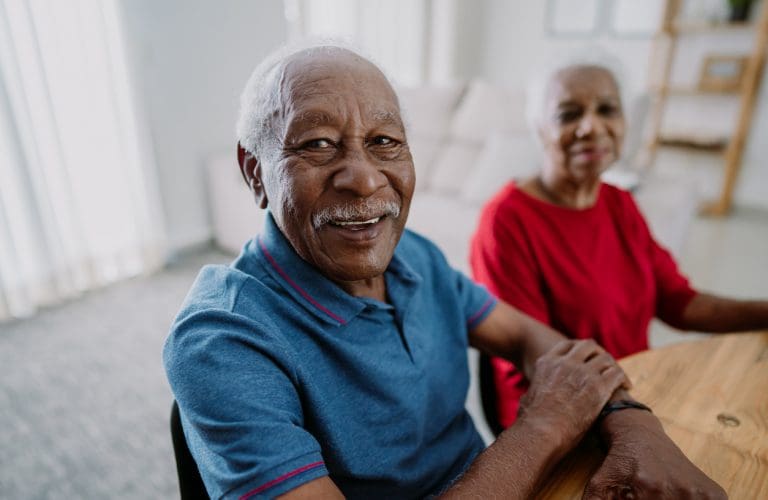 man smiling in blue shirt at senior living community