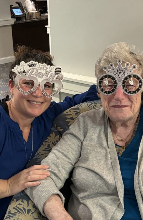 Staff member and resident wearing fun glasses