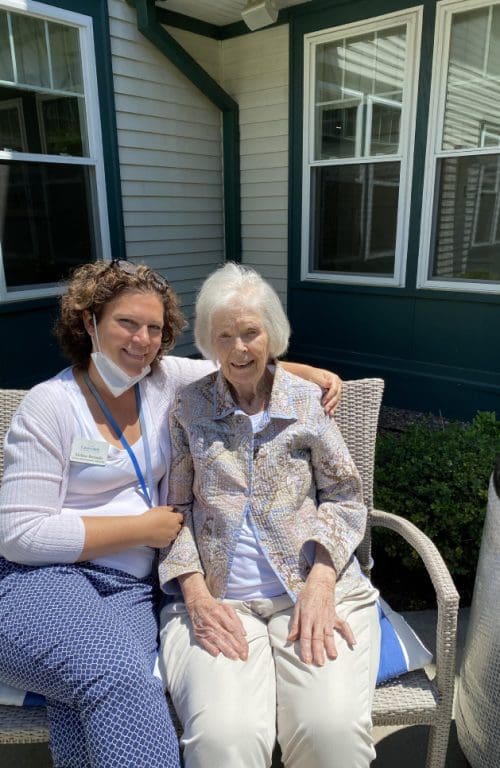 Staff member, Melissa, and a resident sitting outside together